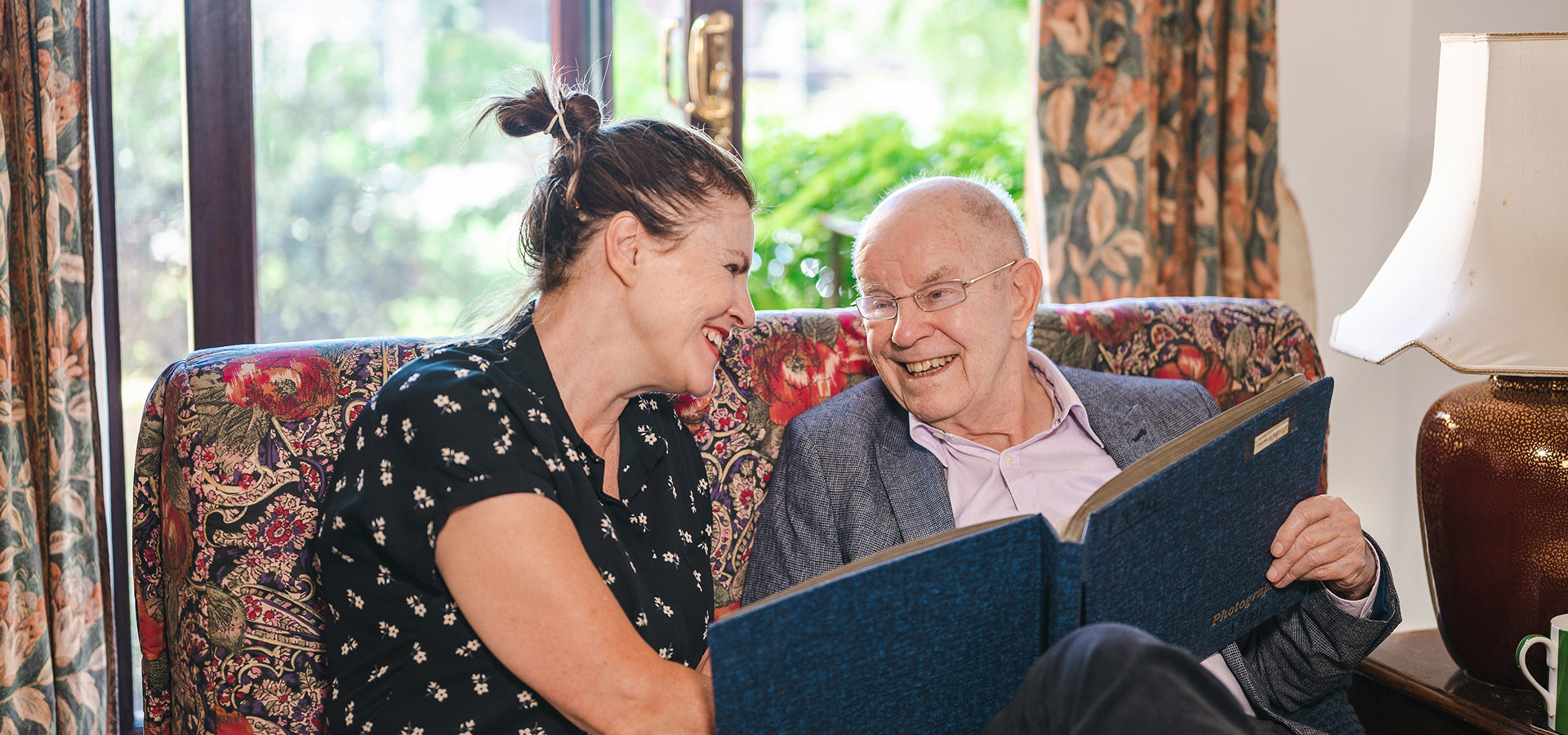 Older adult smiling at home with a carer